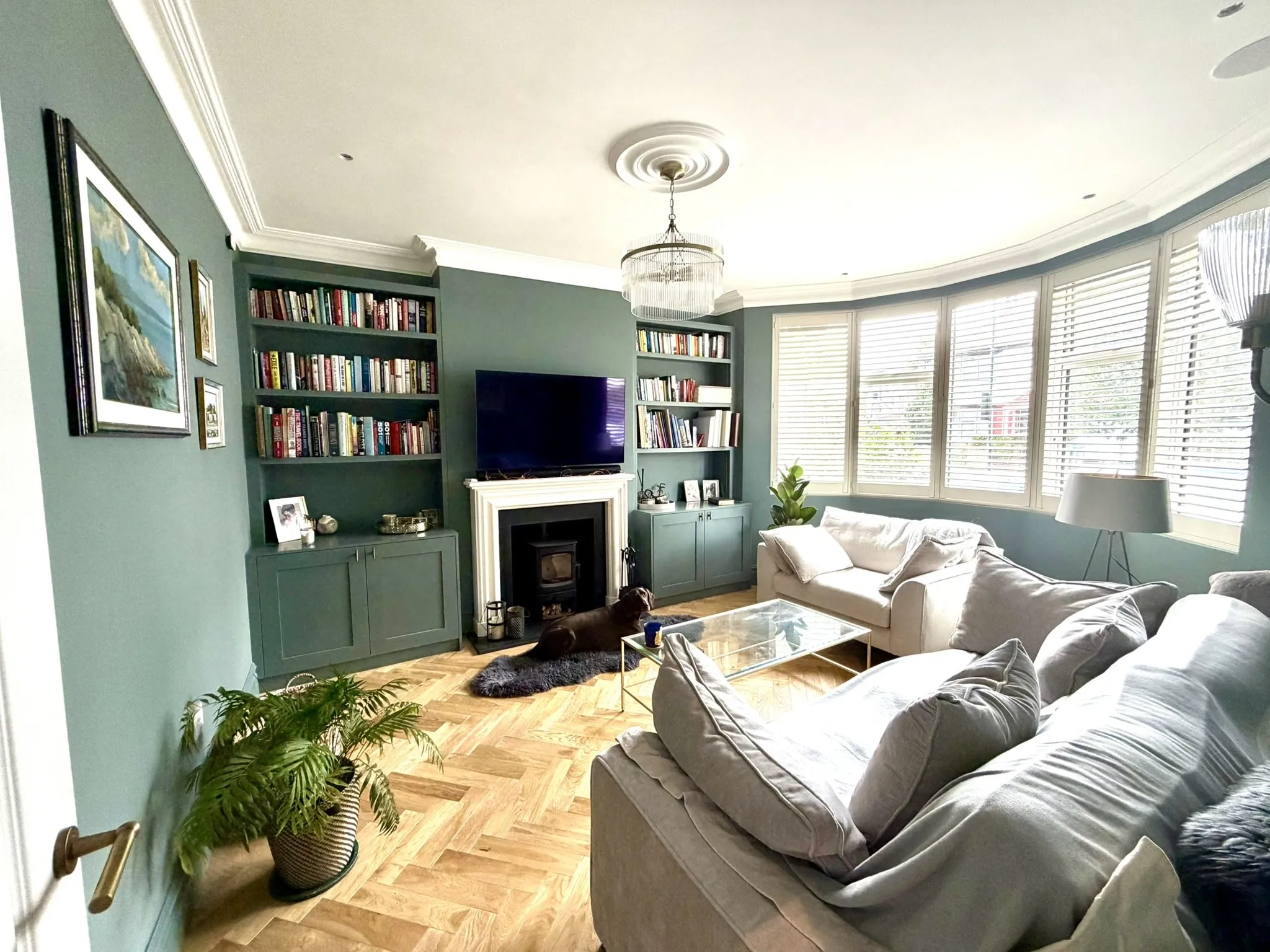 Renovated living room with fitted cabinetry, restored details, and new flooring